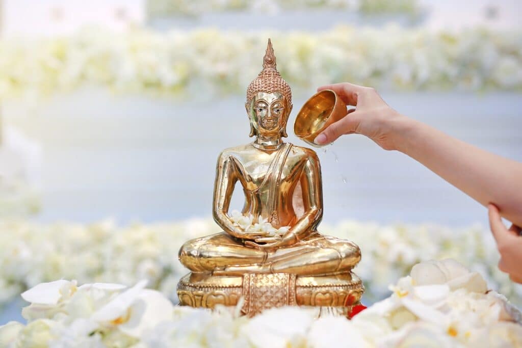 arroser statue de bouddha avec de l'eau